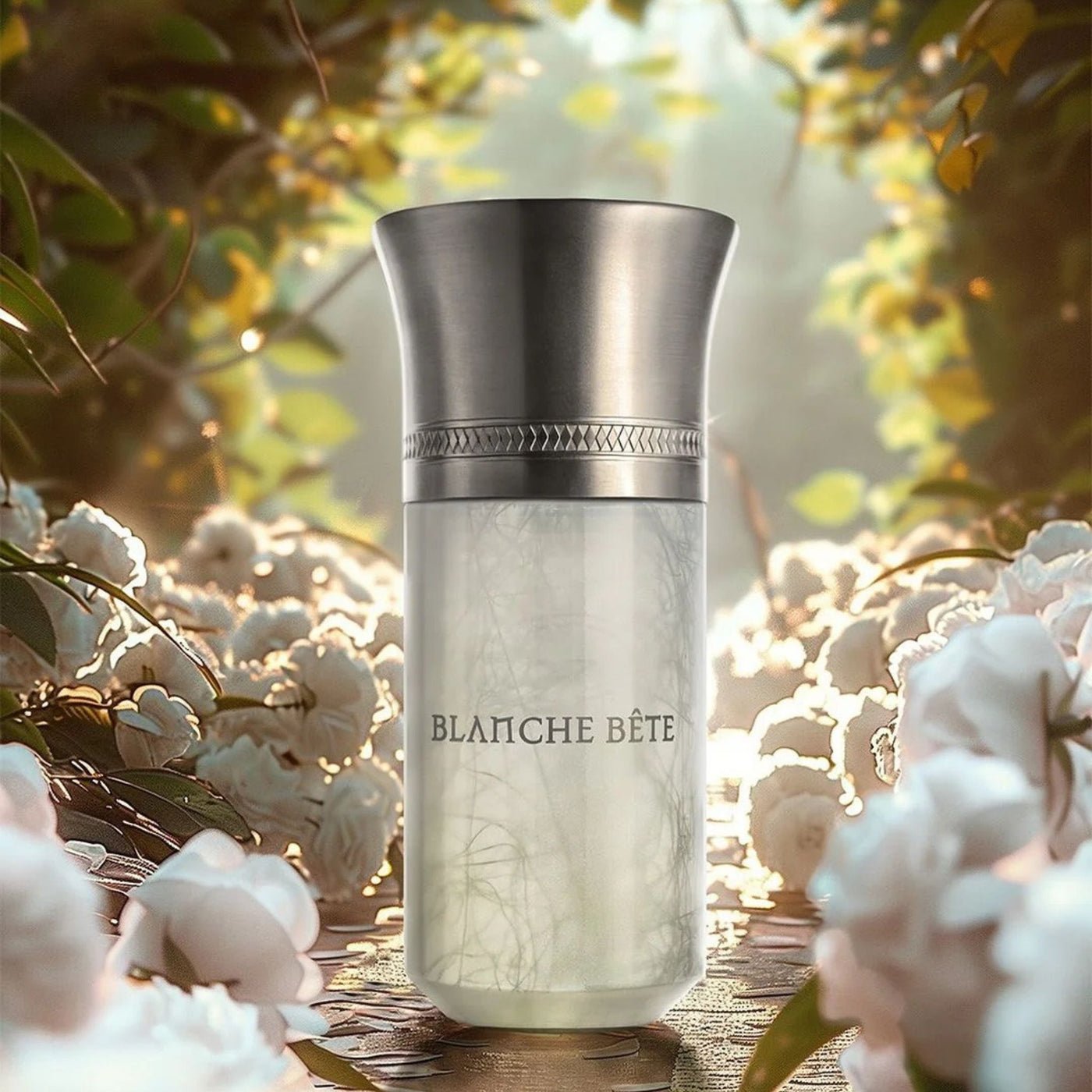 Blanche Bête – parfumerijos buteliukas gėlių fone Blanche Bête – parfumerijos buteliukas gėlių fone