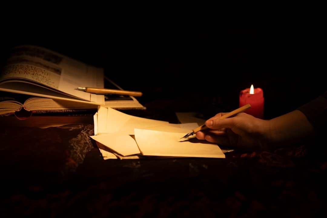 A person writing on paper beside a candle, evoking the archival sources behind the René le Florentin legend